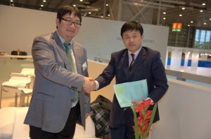 Songwonグループの会長 兼CEOおよび執行委員会ヘッドである朴 鍾昊（パク・ジョンホー）とTangshan Baifu Chemical社およびSongwon Baifu Chemicals (Tangshan)社の会長であるWeiqi Zhangは、2010年に硫黄系酸化防止剤の製造・販売に関する合弁事業の設立に合意した。  SongwonとTangshan Baifu Chemicalは、2012年7月1日に合弁事業Songwon Baifu Chemicals (Tangshan)社を発足させ、このほどチオエステル酸化防止剤の一貫製造体制が整ったことから本格的な操業を開始した。同社は年8,000トンのチオエステル酸化防止剤の製造能力を持つほか、主要中間体原料の製造も行い、Songwonが展開する世界的な一貫生産体制に統合される。 （写真提供：松原産業）